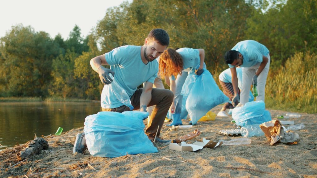 Volunteers collecting trash along a riverbank